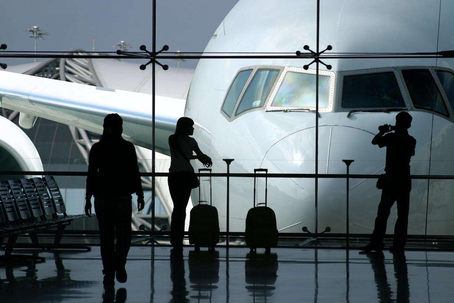 passengers waiting at terminal for travel. High demand for plans creates lines at the airport.