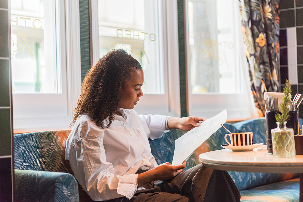 Person sat on a sofa reading a document.