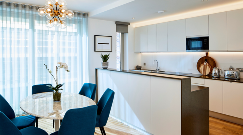 Modern white kitchen and dining area, bright lighting