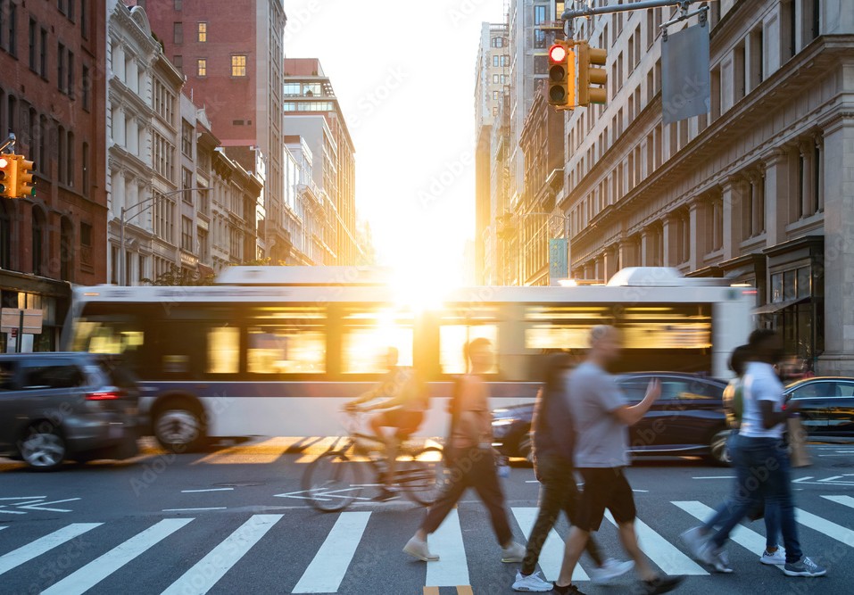 Crowds of busy people walking through the intersection of 5th Avenue and 23rd Street in Manhattan, New York City