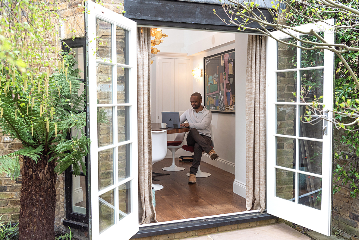 Open patio doors looking into a man working in his luxury property