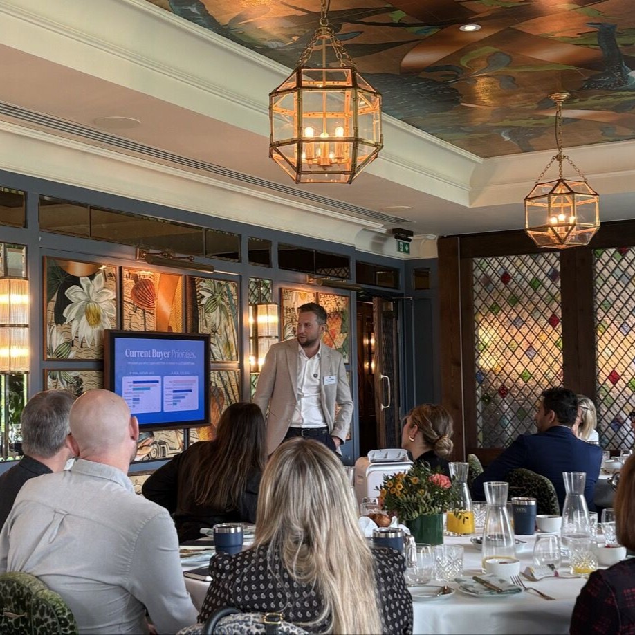 Martin Klima gives a presentation to an audience seated at tables in an elegant meeting room